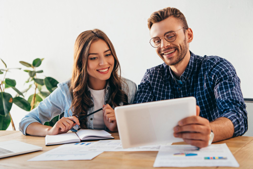 smiling-business-colleagues-with-tablet-taking-part-webinar-together-office